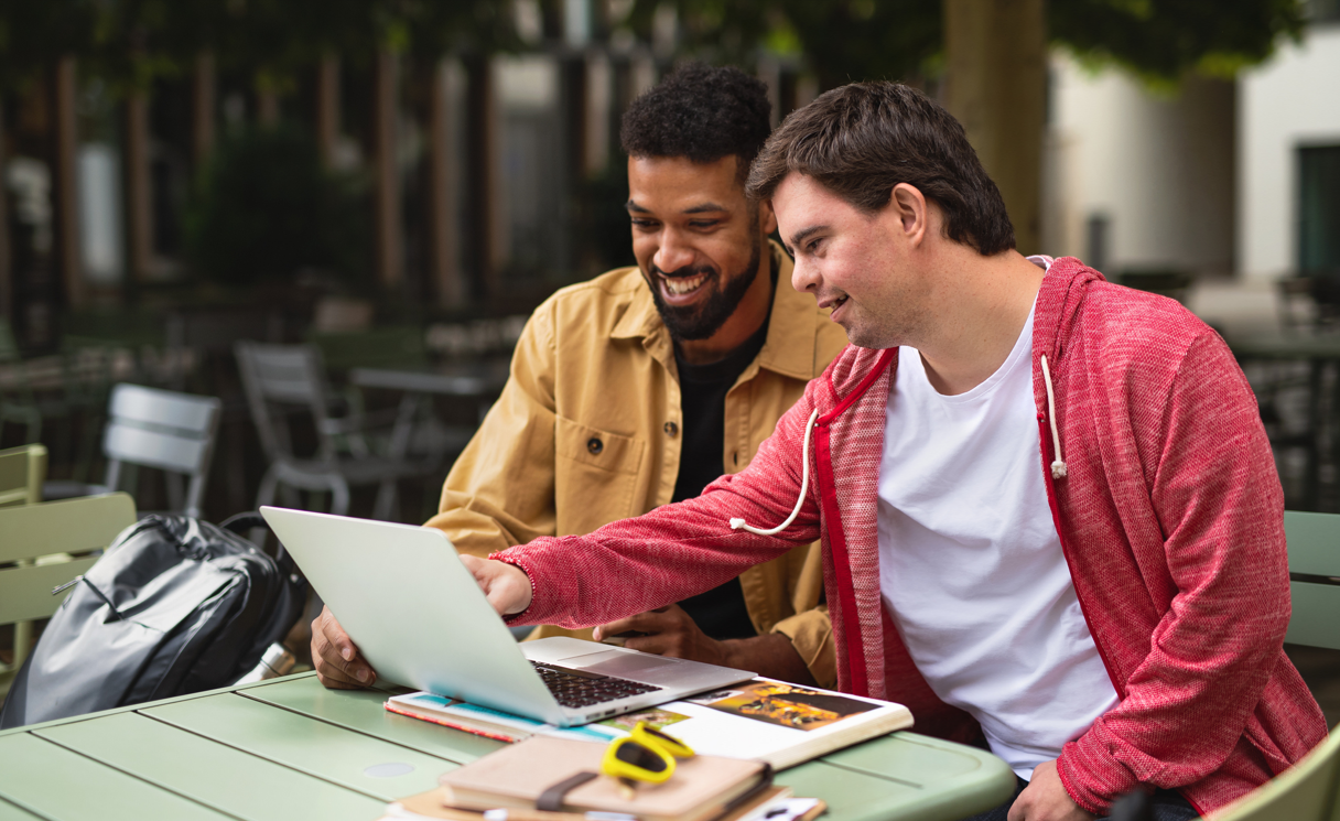 two people pointing at a computer