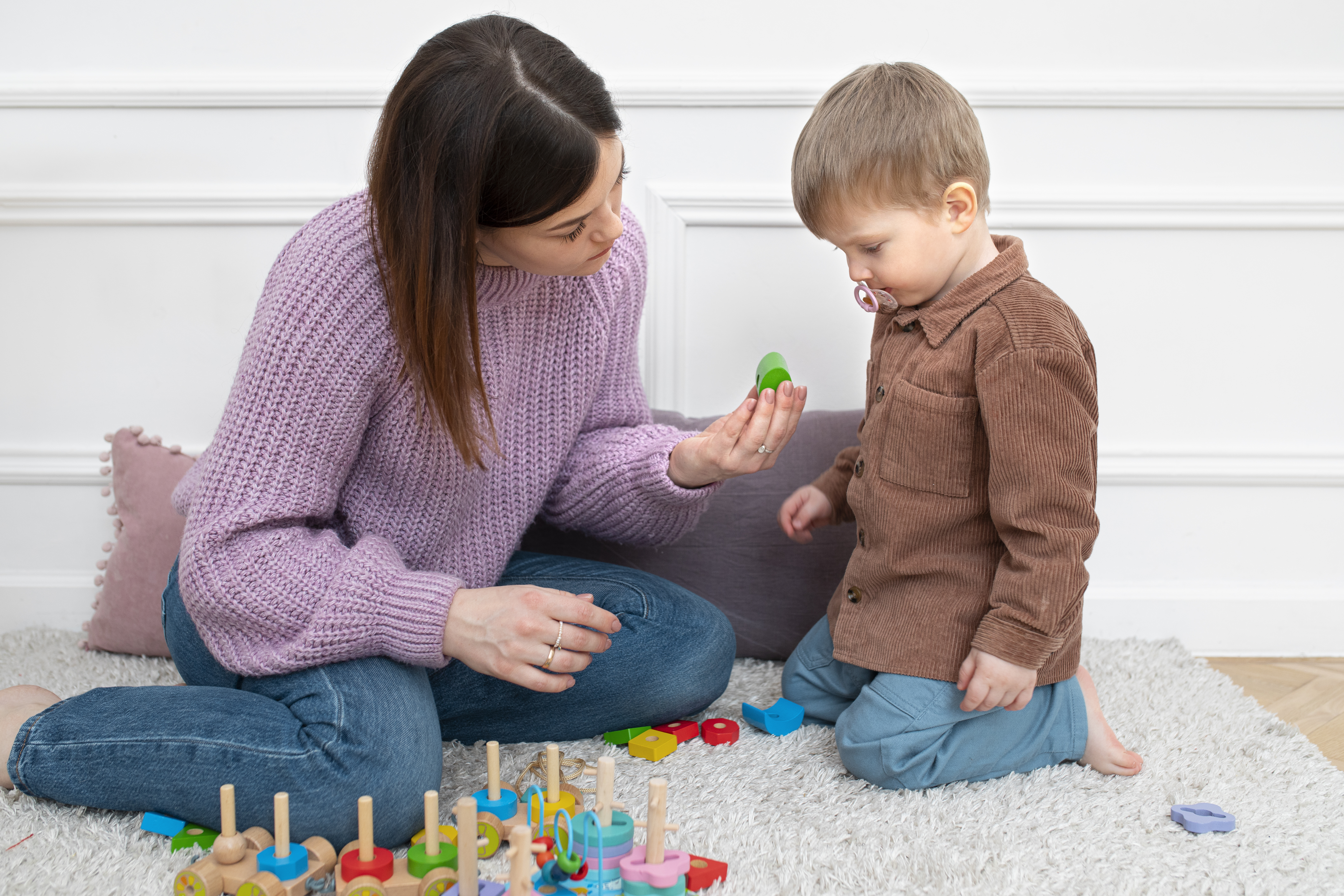 Image of woman and young child playing with toys