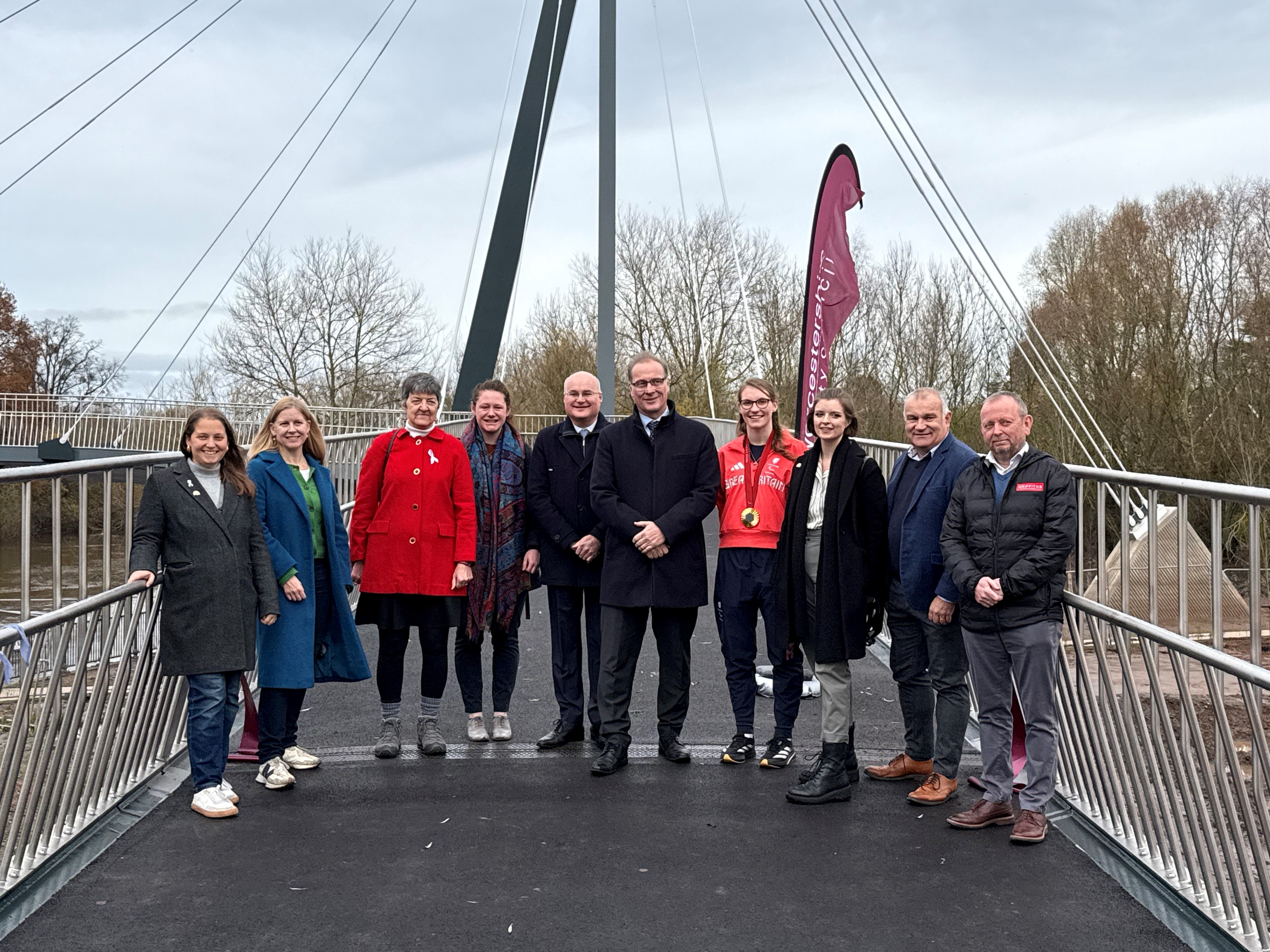 A group of representatives stand on the bridge from Worcestershire County Council, Worcester City Council, Alun Griffiths Limited, and the Worcestershire Local Enterprise Partnership, alongside Rebecca Redfern MBE.