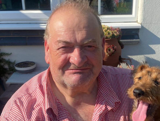 Councillor Adrian Hardman sitting at home with his dog