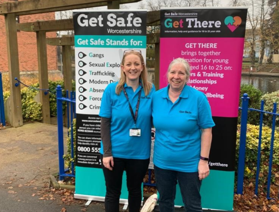 Members of the Get Safe team stand in front of Get Safe Banners