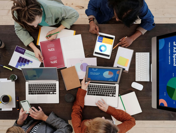 Image of people sat around a table, using laptops