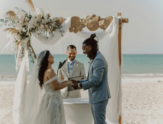 Image of a couple getting married on a beach with a celebrant