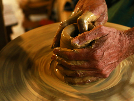 Image of a person sculpting clay on a wheel