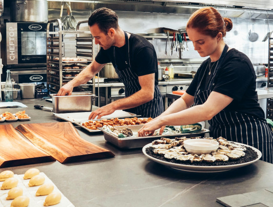 Image of two chefs cooking food in a kitchen