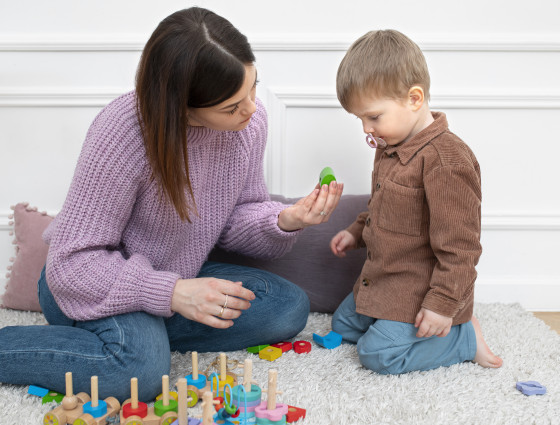 Image of woman and young child playing with toys