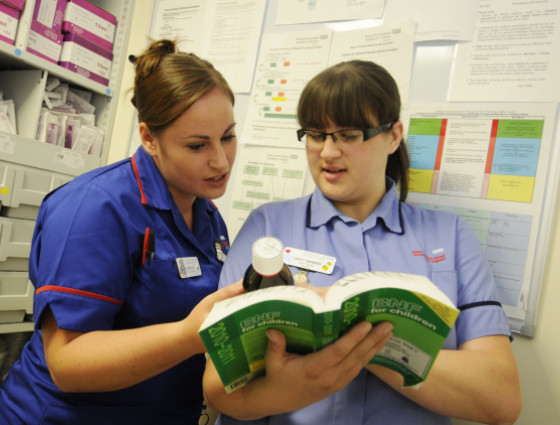 Image of two nurses looking at medicine together