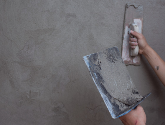 Image of a person using tools to plaster a wall