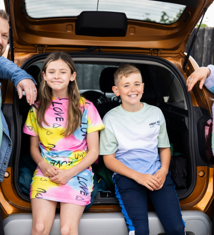 Children sitting in a car boot